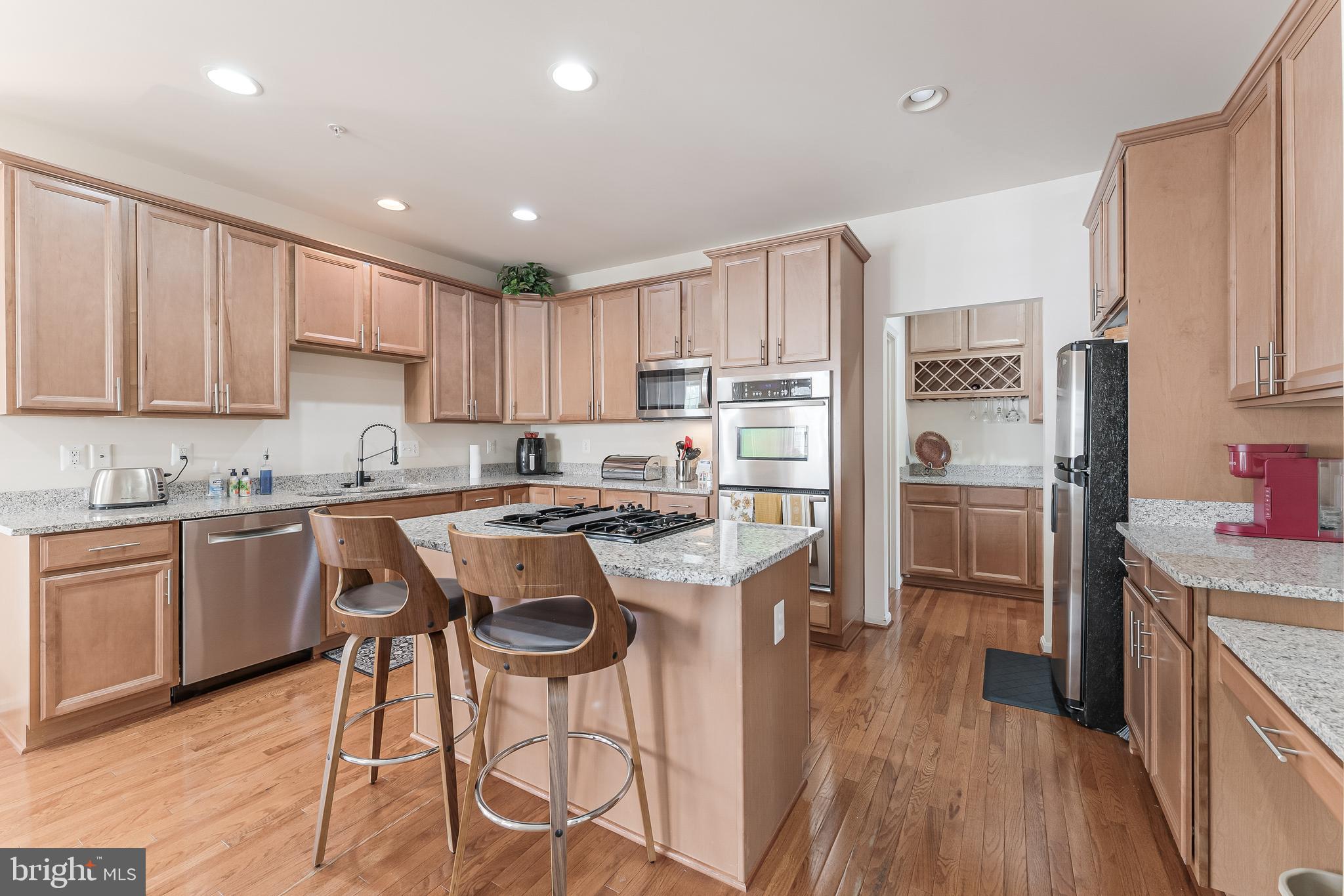 2326 Campus Way North Bowie, MD 20721 - Photo 4 of 31 a kitchen with kitchen island granite countertop wooden floors appliances and sink