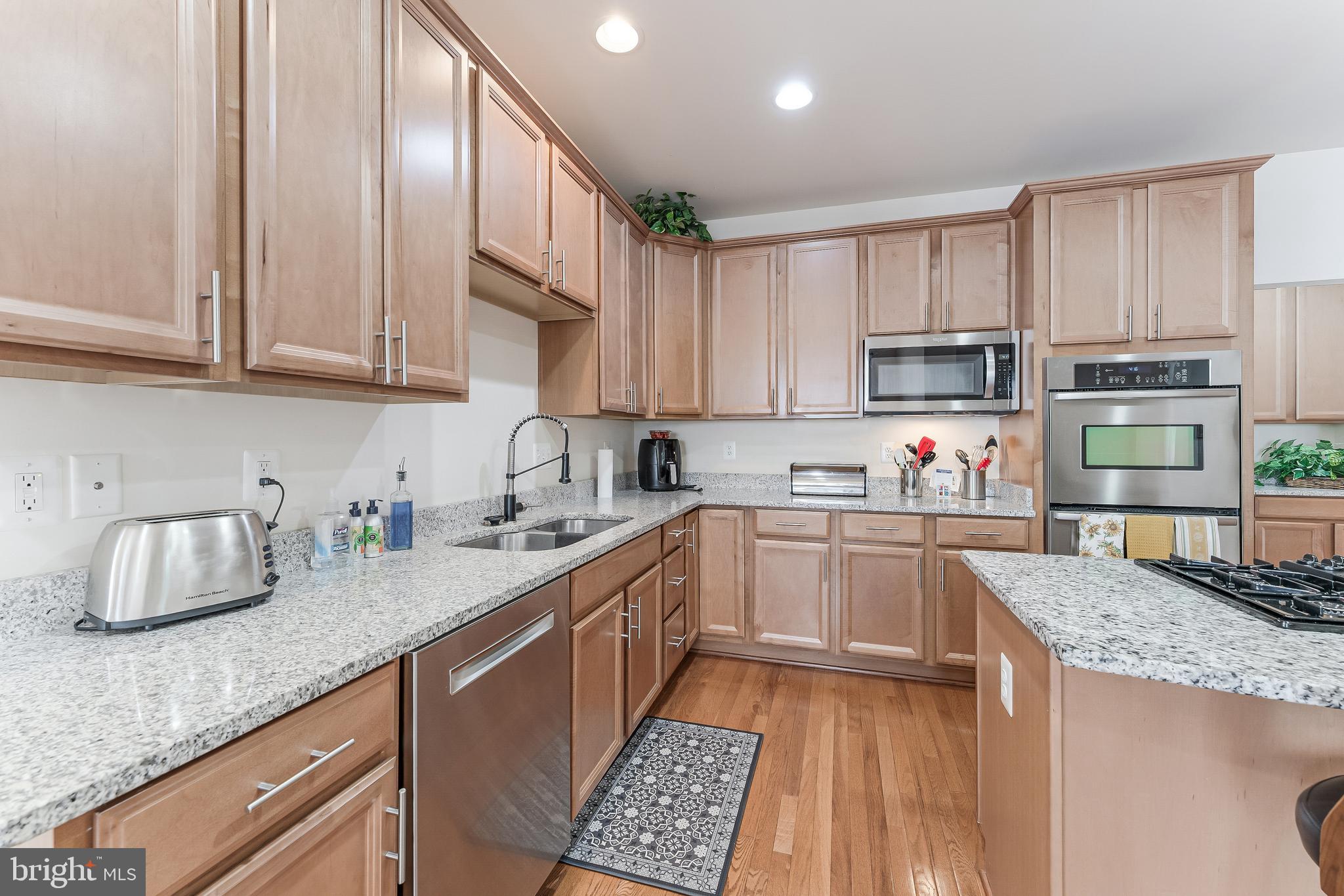 2326 Campus Way North Bowie, MD 20721 - Photo 5 of 31 a kitchen with granite countertop a sink dishwasher stove and cabinets with wooden floor