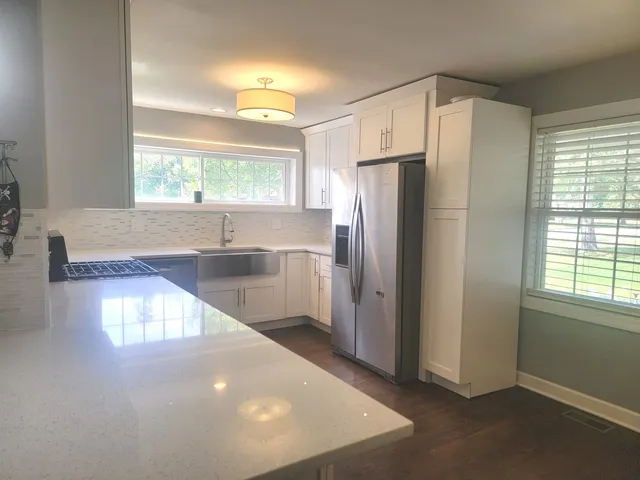 a view of kitchen with windows and refrigerator
