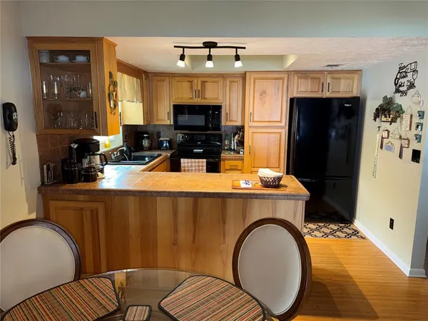 a living room with furniture a flat screen tv and kitchen view