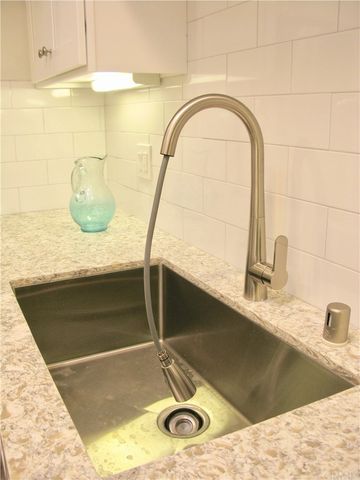 a bathroom with a granite countertop sink a mirror and shower
