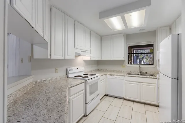 a kitchen with stainless steel appliances granite countertop white refrigerator stove a sink and dishwasher