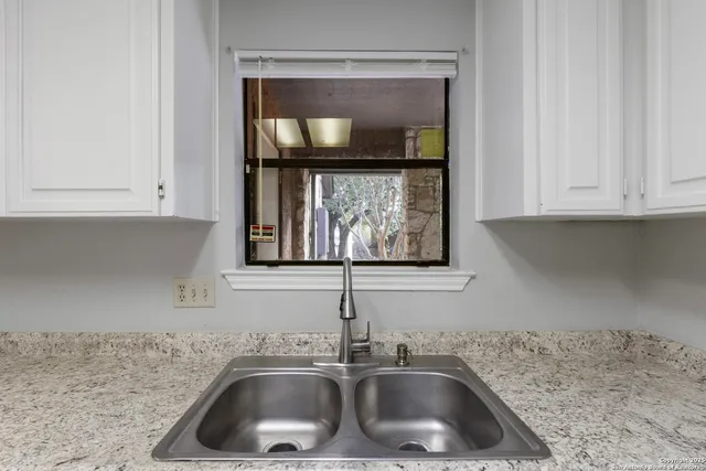 a kitchen with granite countertop white cabinets and white appliances