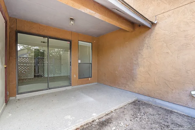 a view of an empty room with wooden floor fireplace and a window