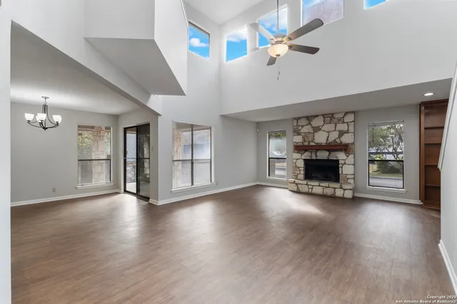 a view of an empty room with a fireplace and a fan