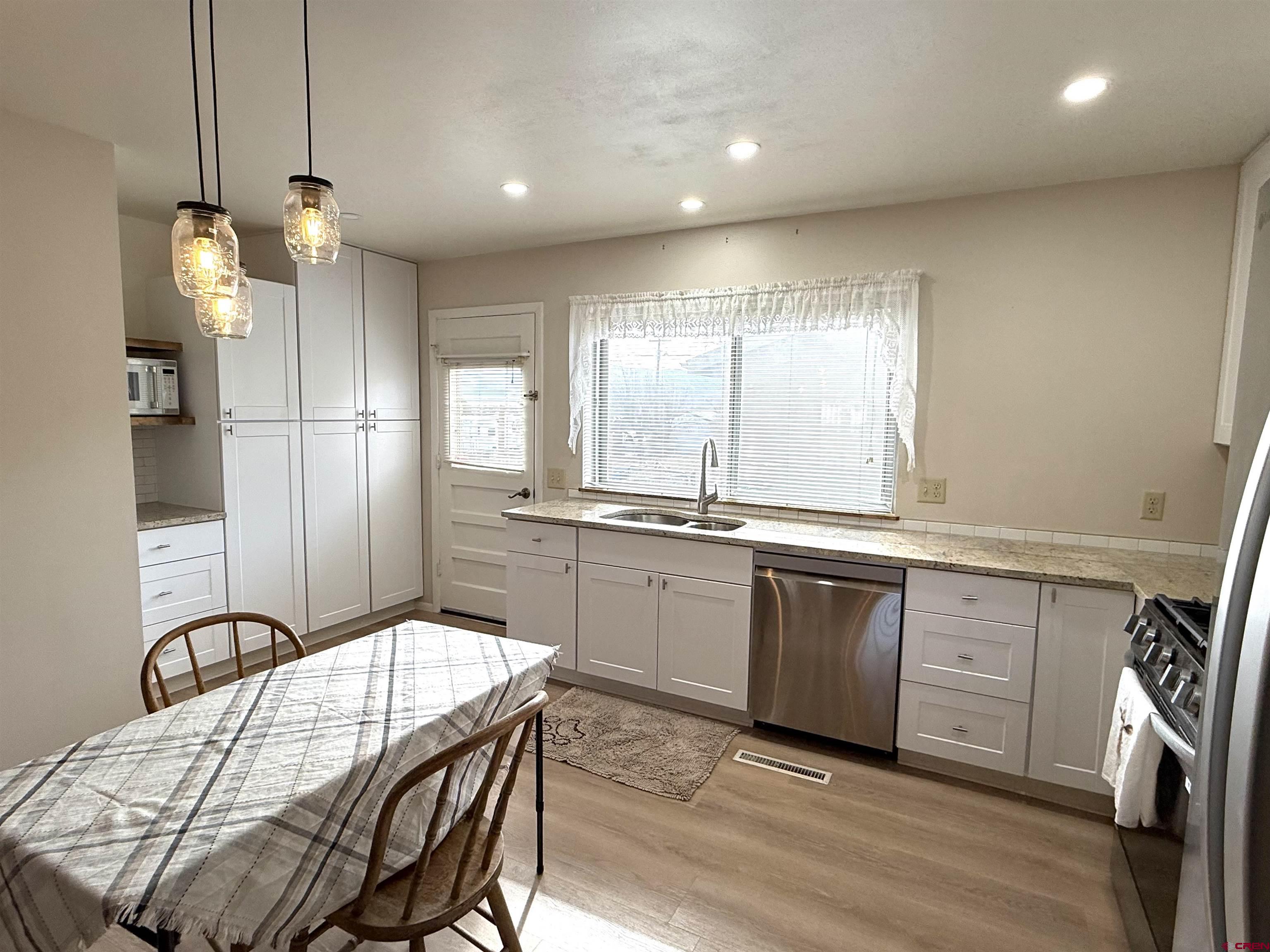 801 East 3rd Street Cortez, CO 81321 - Photo 11 of 22 a kitchen with granite countertop white cabinets and stainless steel appliances
