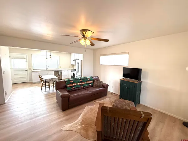 a living room with furniture a large window and a flat screen tv