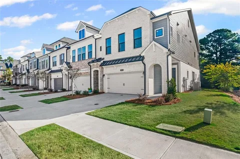 a view of a white house with yard and plants