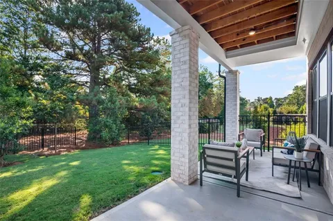 a view of a patio with chairs and floor to ceiling window