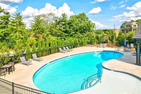 a view of a swimming pool with a yard and sitting space