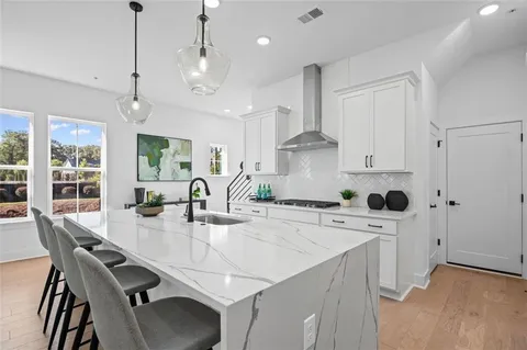 a kitchen with stainless steel appliances a stove a table chairs and a refrigerator