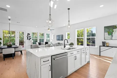 a large white kitchen with a large window and stainless steel appliances