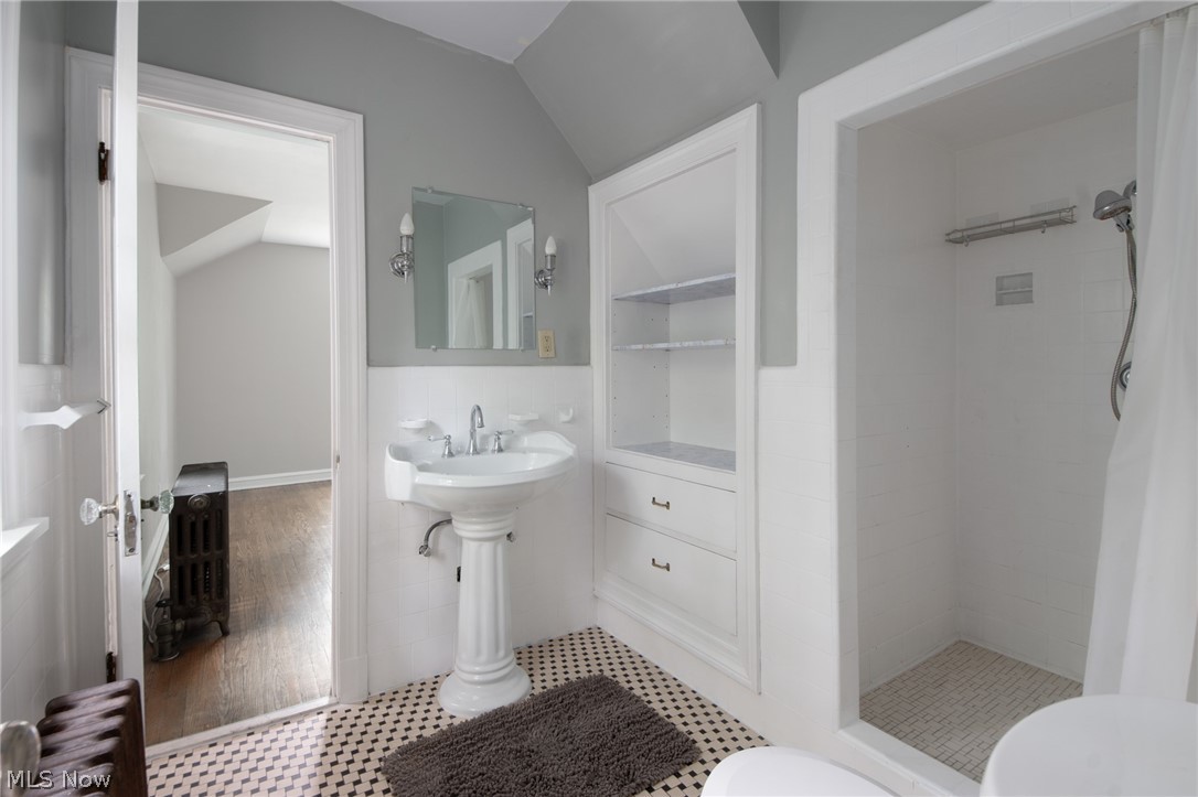 3133 Keswick Road Cleveland, OH 44120 - Photo 18 of 35 Bathroom with tile patterned flooring, lofted ceiling, tiled shower, toilet, and radiator