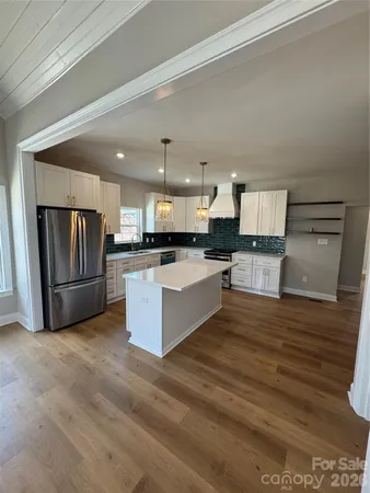 a large kitchen with a center island and stainless steel appliances