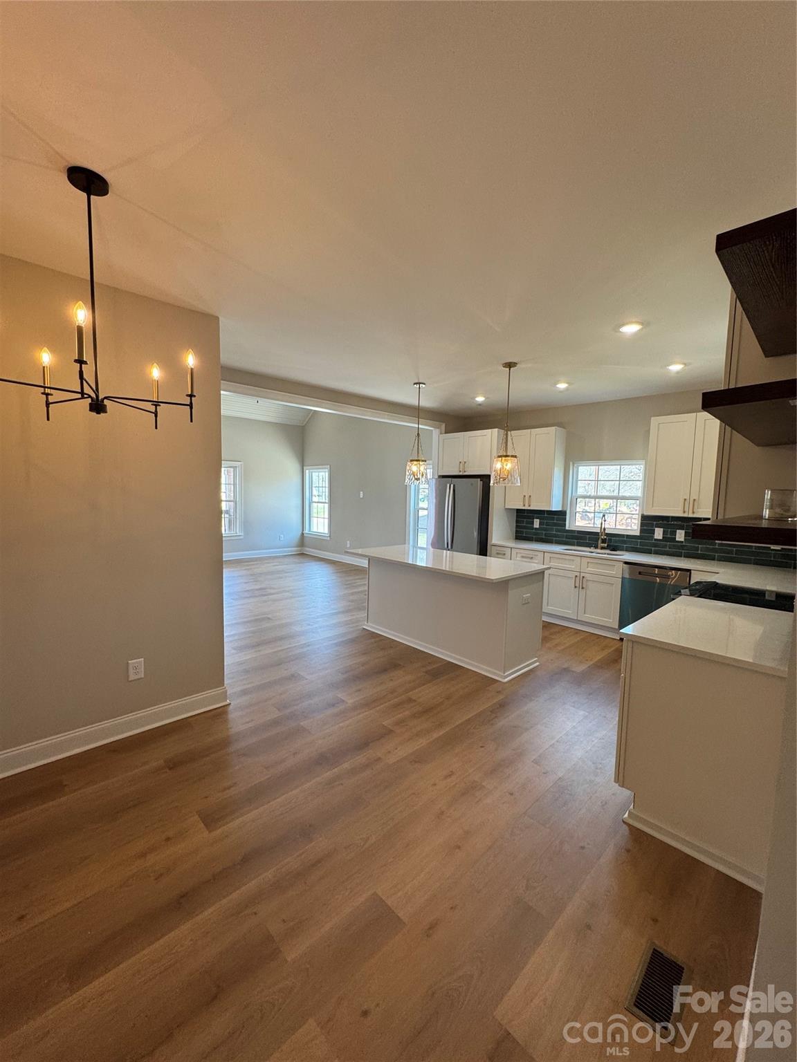 203 Lee Street Fort Mill, SC 29715 - Photo 5 of 19 a view of a kitchen with kitchen island wooden floor and stainless steel appliances