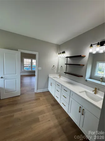 a spacious bathroom with double vanity and a mirror
