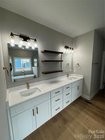 a bathroom with double sink and three mirror