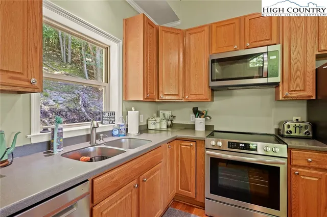 a kitchen with stainless steel appliances a stove a sink a microwave and cabinets