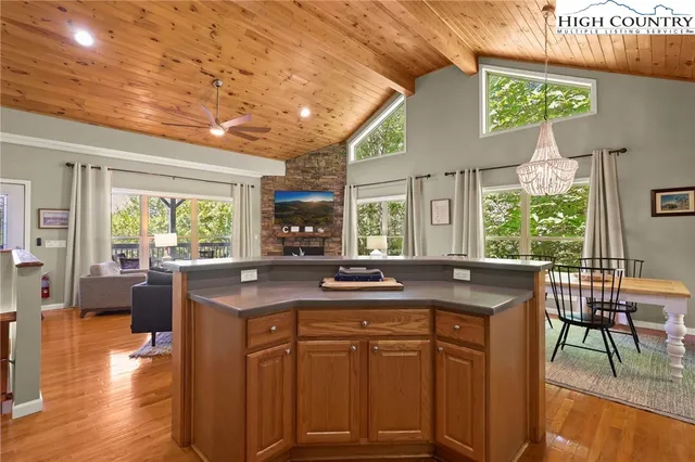 a kitchen with kitchen island granite countertop a table chairs stove and sink
