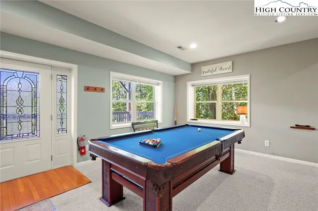 a room with pool table and windows