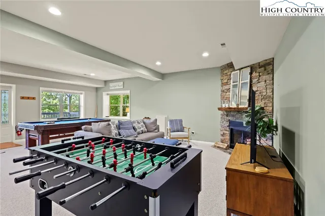 a living room with furniture stove and large window