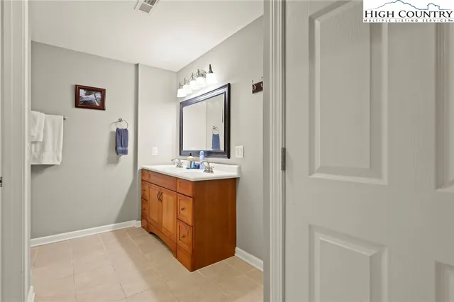 a bathroom with a double vanity sink and a mirror