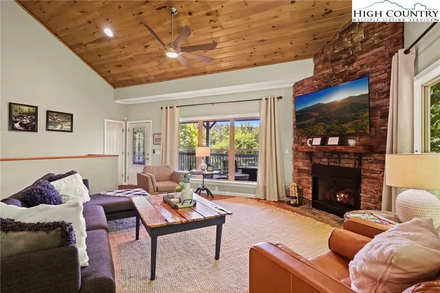 a living room with furniture a fireplace and a flat screen tv