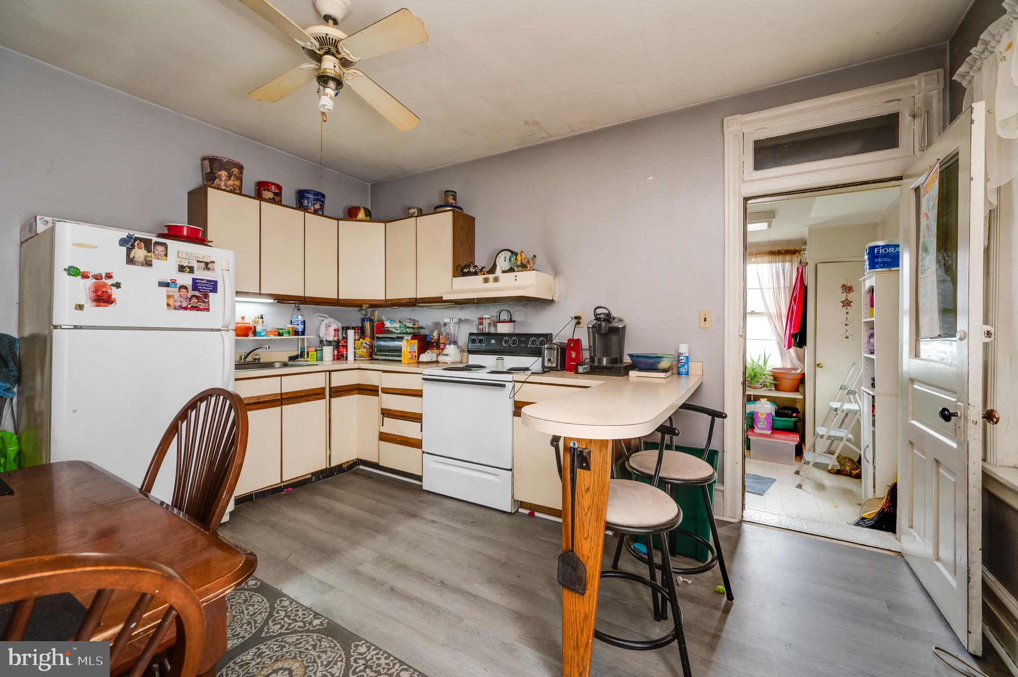 1642 Mineral Spring Road Reading, PA 19602 - Photo 14 of 56 a kitchen with a refrigerator a sink dishwasher a dining table and chairs with wooden floor