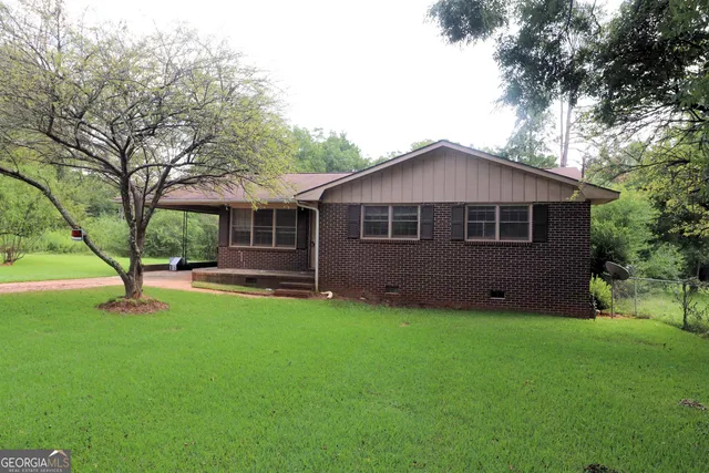 a view of a house with a yard and a tree