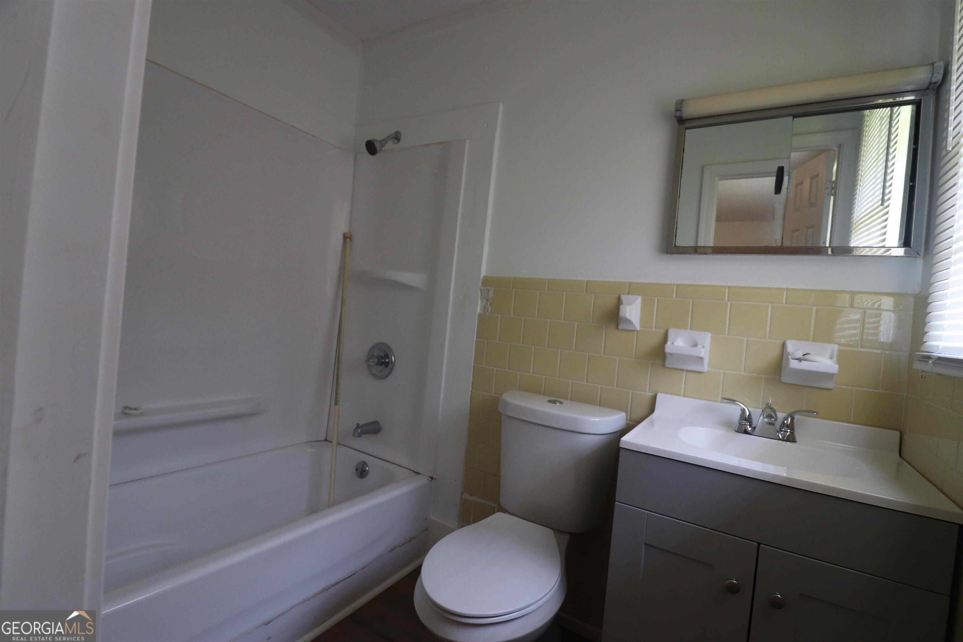 156 Deacon J Simmons Road Southwest Milledgeville, GA 31061 - Photo 11 of 12 a bathroom with a toilet a sink a mirror and bathtub