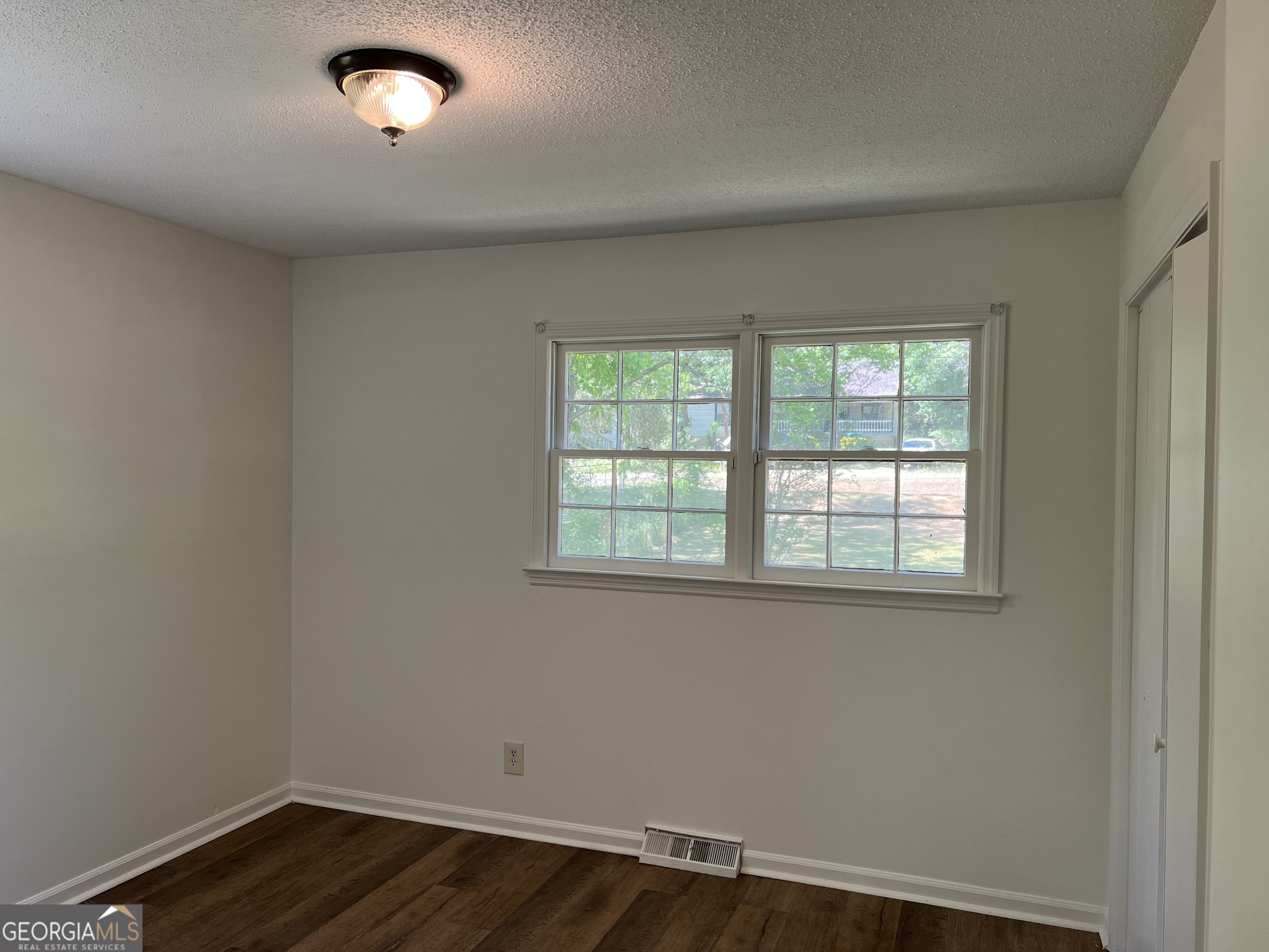 156 Deacon J Simmons Road Southwest Milledgeville, GA 31061 - Photo 15 of 22 an empty room with wooden floor and windows
