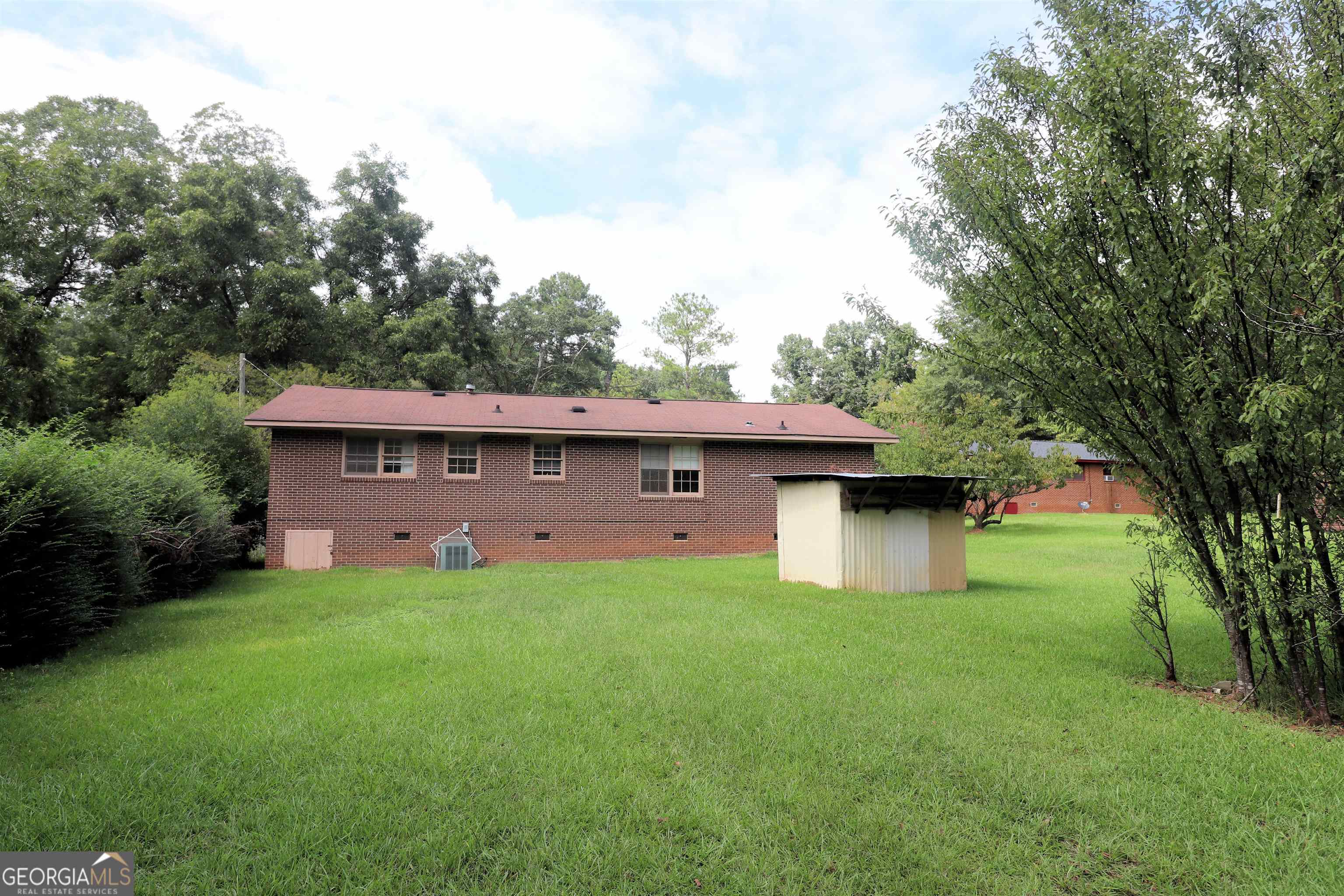 156 Deacon J Simmons Road Southwest Milledgeville, GA 31061 - Photo 3 of 12 a view of a deck in front of a house with a big yard