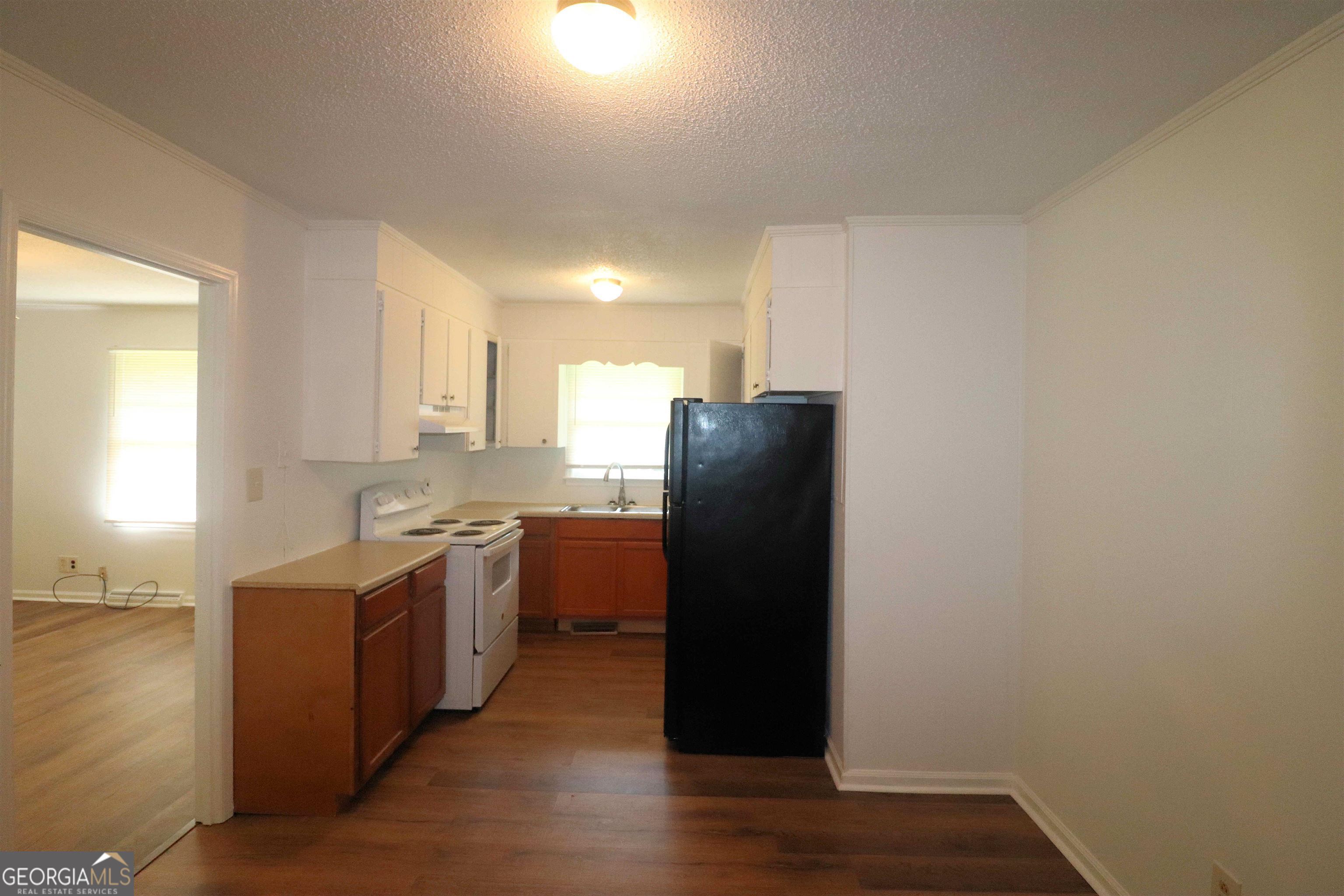 156 Deacon J Simmons Road Southwest Milledgeville, GA 31061 - Photo 7 of 12 a kitchen with stainless steel appliances granite countertop a refrigerator a sink a stove and wooden floor