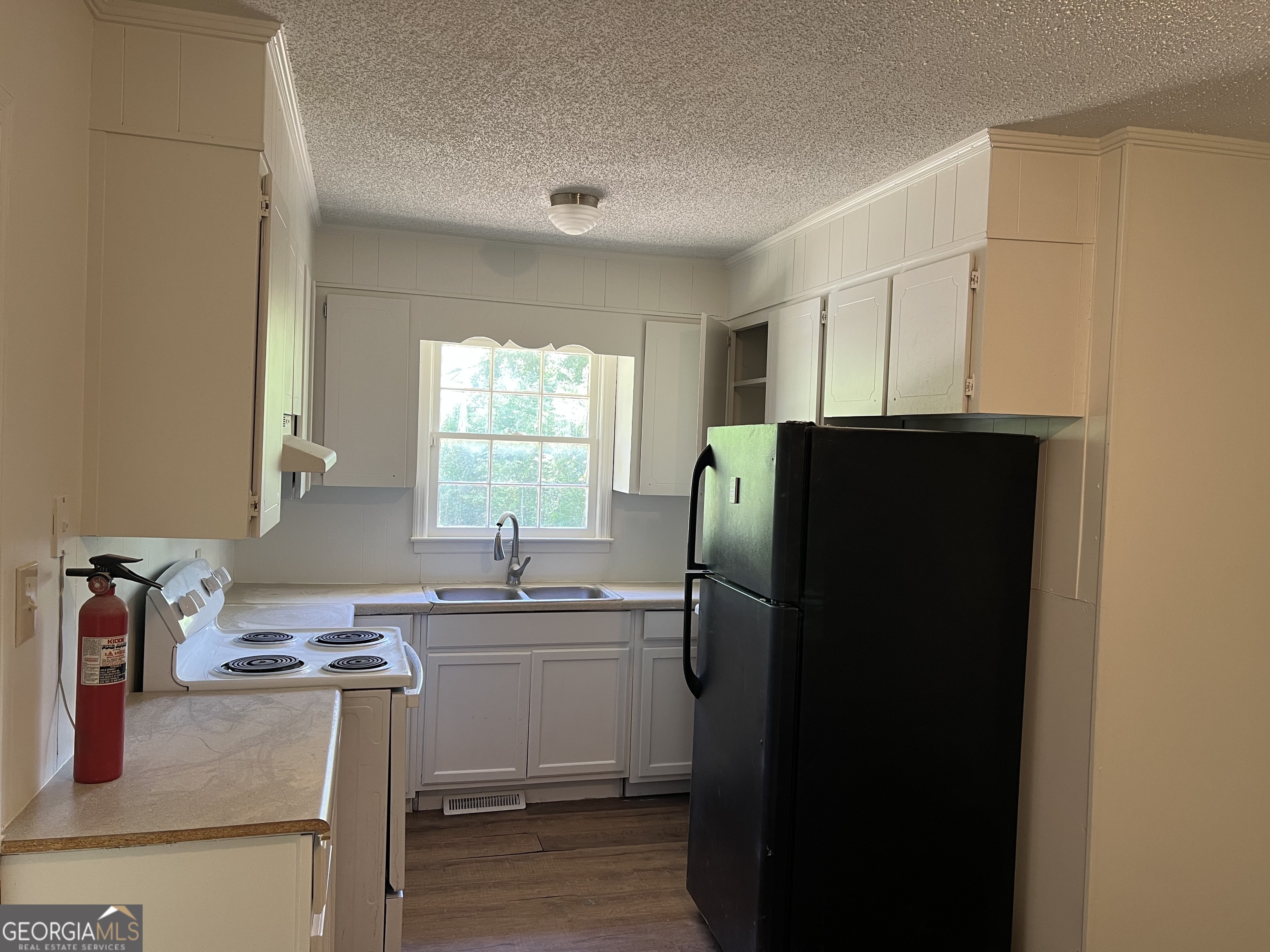 156 Deacon J Simmons Road Southwest Milledgeville, GA 31061 - Photo 9 of 22 a kitchen with a refrigerator and a sink