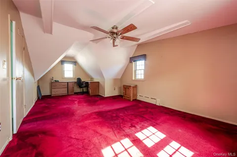 a view of an empty room with window and chandelier fan