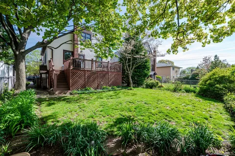 a view of a house with backyard and a tree