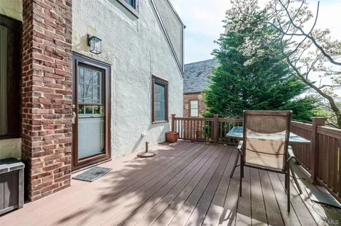 a balcony with wooden floor table and chairs