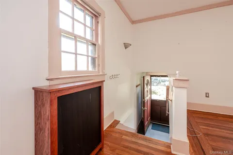 a view of a hallway with wooden floor and a living room