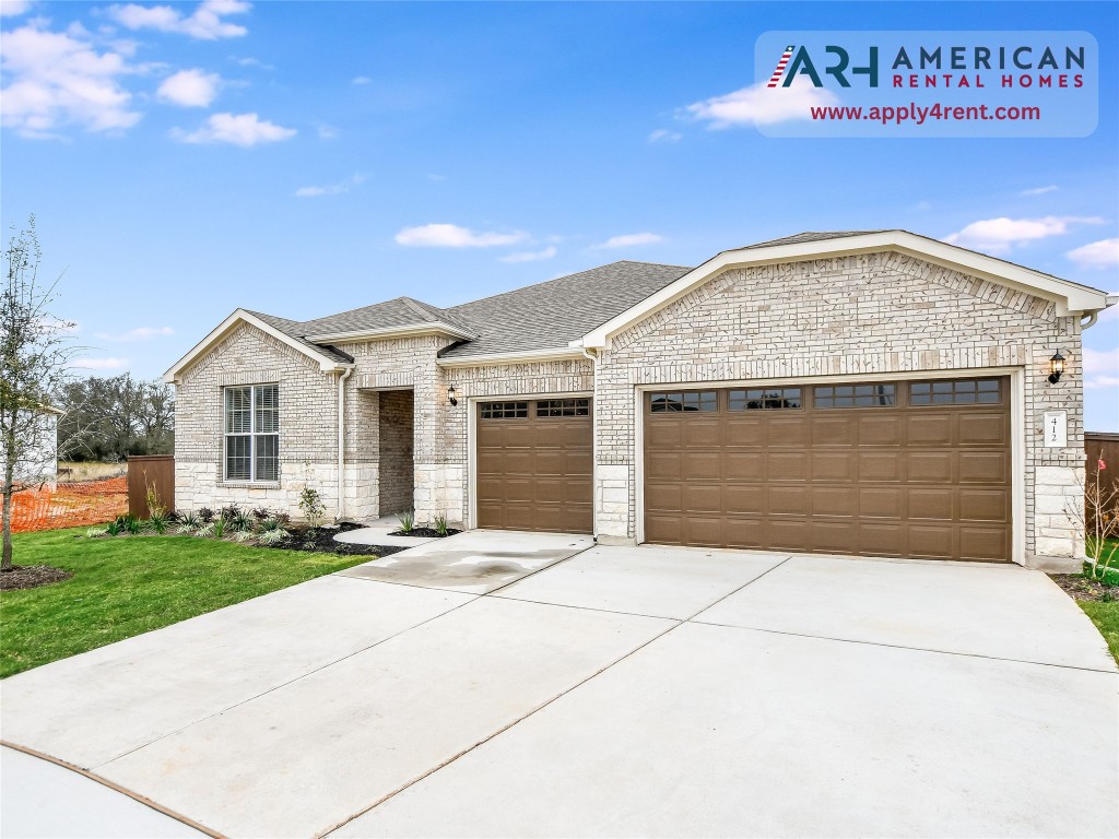 412 Copperleaf Cove Marble Falls, TX 78654 - Photo 1 of 40 View of front of home with an attached garage, concrete driveway, roof with shingles, a front yard, and brick siding