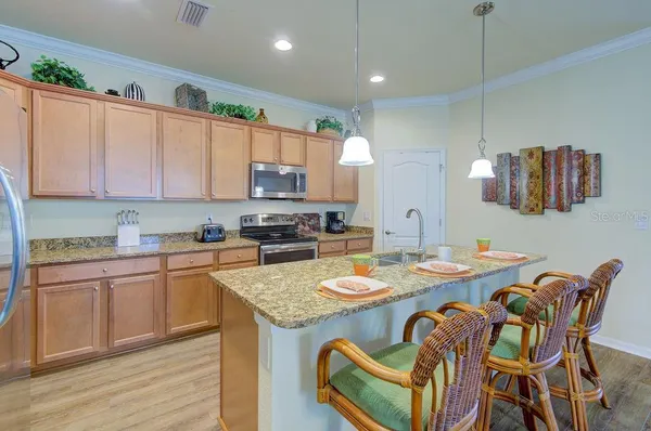 a kitchen with stainless steel appliances granite countertop a stove a sink and a microwave