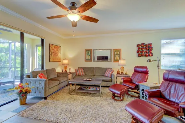 a living room with furniture kitchen view and a wooden floor