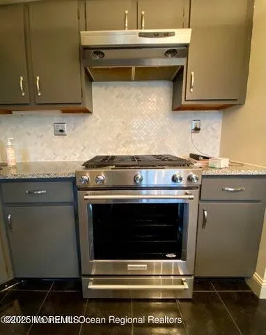 a stove top oven sitting inside of a kitchen