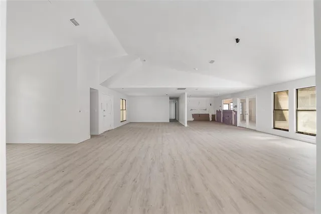a view of empty room with wooden floor and window