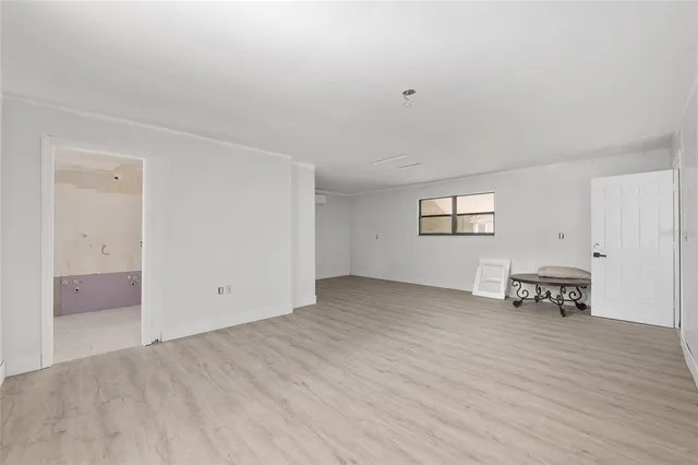 an empty room with wooden floor and a window