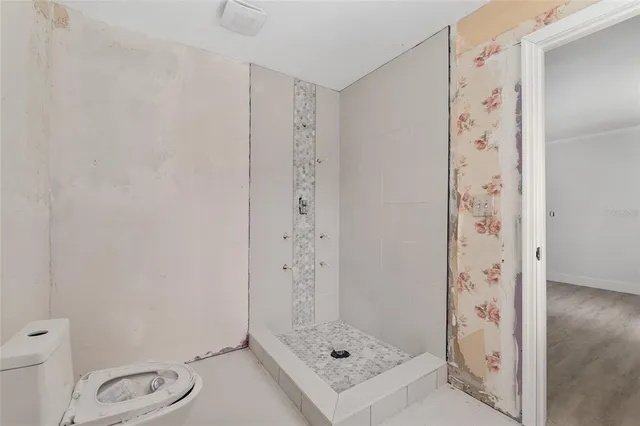 a bathroom with a shower toilet and sink
