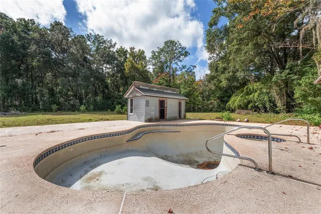 a view of a house with pool and sitting area
