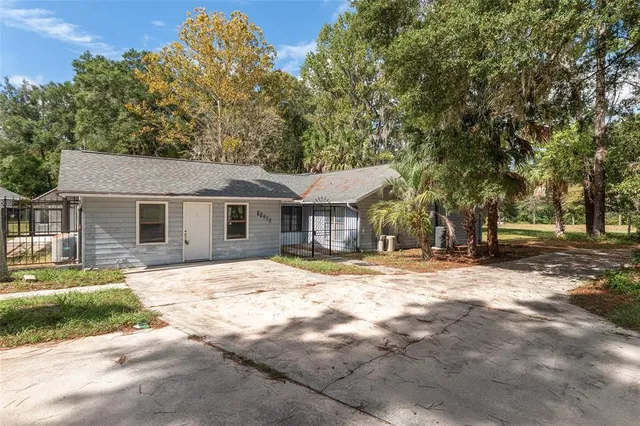 a view of a house with backyard and trees