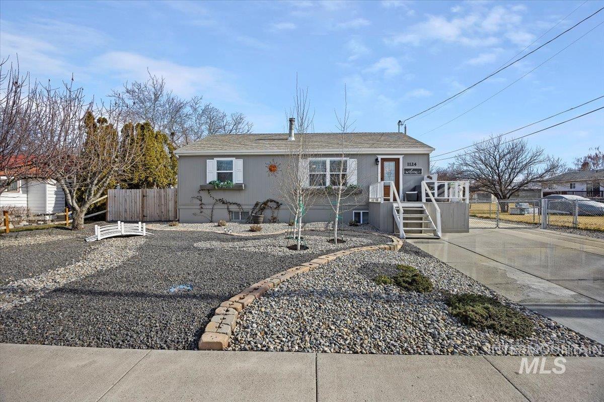 View of front facade with a shingled roof and a gate