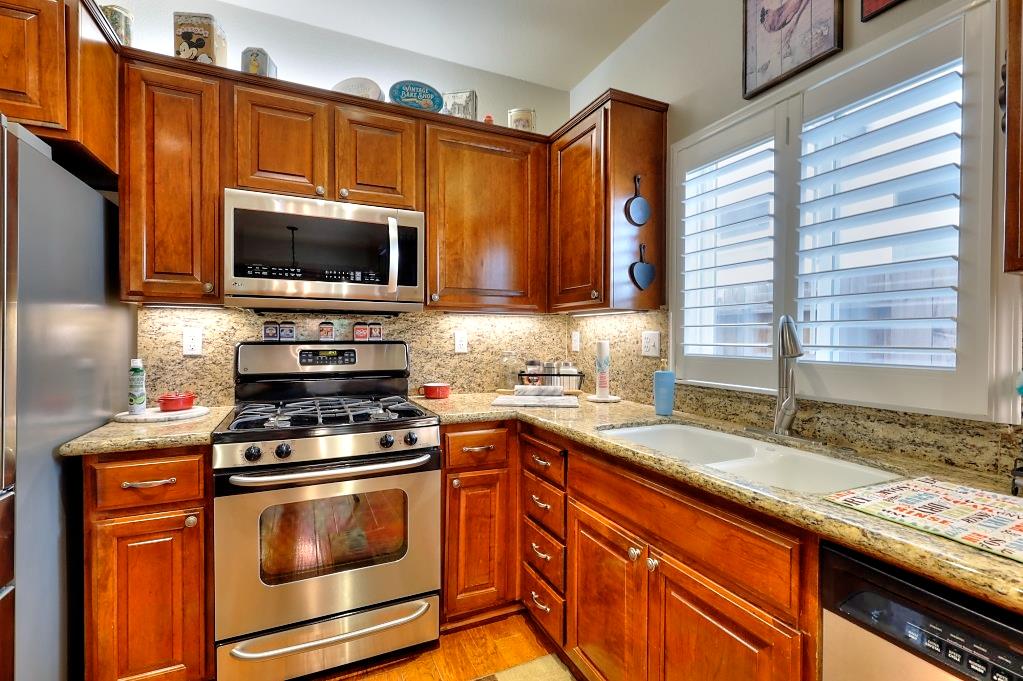 4152 Post Oak Drive Turlock, CA 95382 - Photo 27 of 71 a kitchen with granite countertop a sink a counter top space cabinets stainless steel appliances and a window
