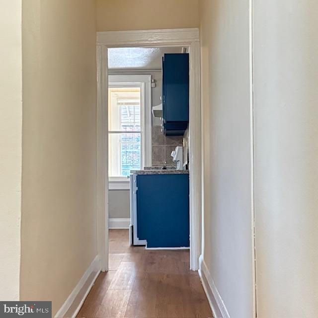 2891 Pelham Avenue Baltimore, MD 21213 - Photo 2 of 11 an empty room with wooden floor cabinet and mirror